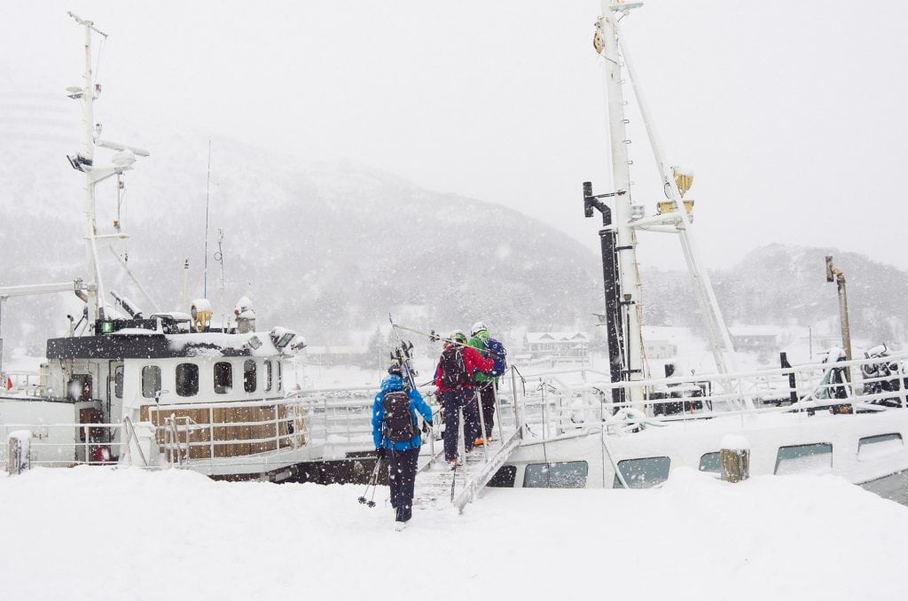 Skiers arriving by boat on Vannøya in winter
